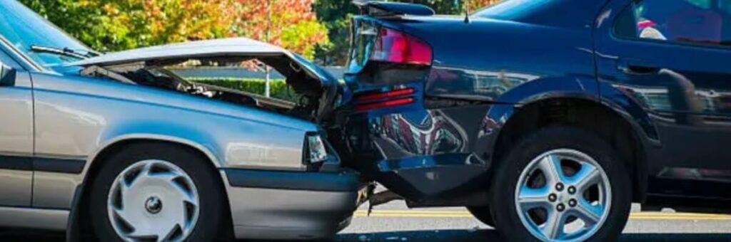 A rear-end collision between two cars, representing potential auto insurance fraud in staged accidents.