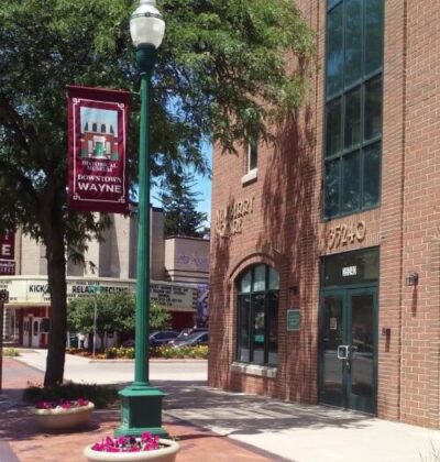Downtown Wayne, Michigan, featuring brick buildings, a streetlight, and a banner showcasing the vibrant local community.